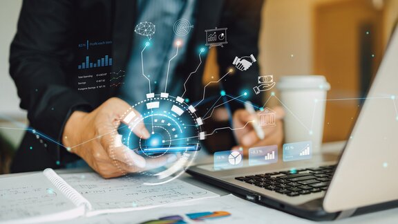 Osoba koristi laptop sa digitalnim ikonama i grafovima_Rox