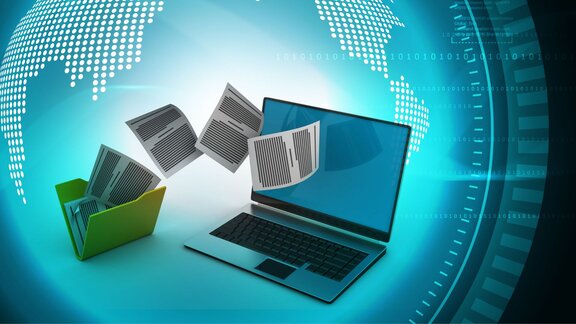 © iStockphoto/brijith vijayan "Digital documents moving from a physical folder into a laptop screen, symbolizing document digitization and global data exchange, with a stylized globe and binary code in the background