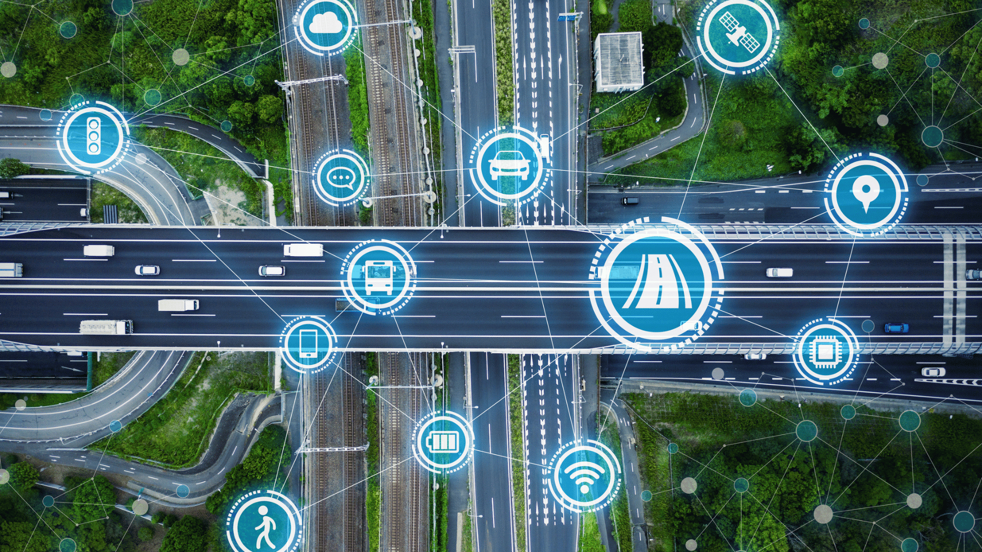 Aerial view of a highway intersection with connected vehicle and smart mobility icons illustrating IoT-based intelligent transportation and digital traffic management.