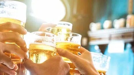 Hands holding beers coming together in the air