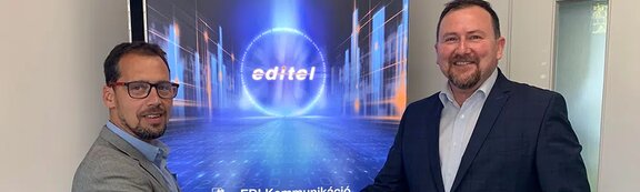 Businessmen smiling in front of a screen with the EDITEL logo