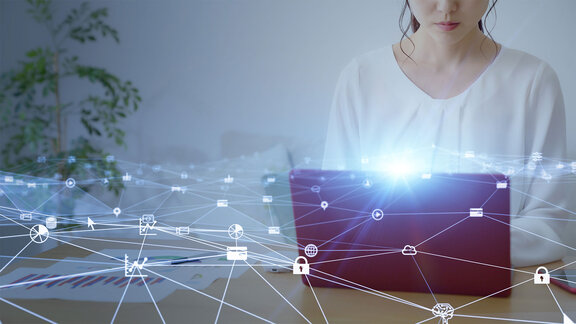 Woman working on a laptop with digital network icons and connections overlayed