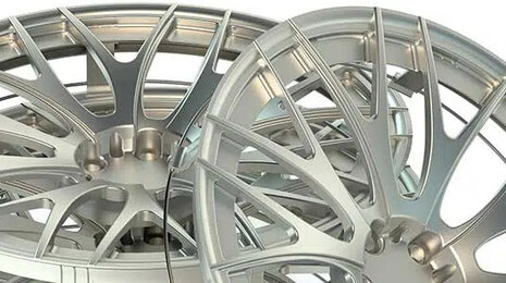 Close-up of stacked silver alloy car rims with a multi-spoke design, photographed on a white background.