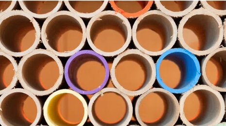 Stacked tubes with colored interiors forming circular patterns, symbolizing diversity and structure