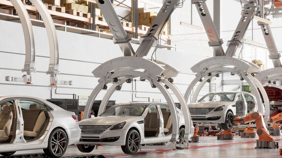 Robotic arms assembling cars on a production line, showcasing advanced manufacturing technology