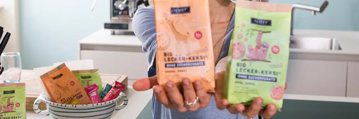 © chrissinger.com EDI Services for Nussyy: Young woman holds two packets of muesli in her hand