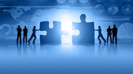 Personen, die Puzzleteile zusammenschieben