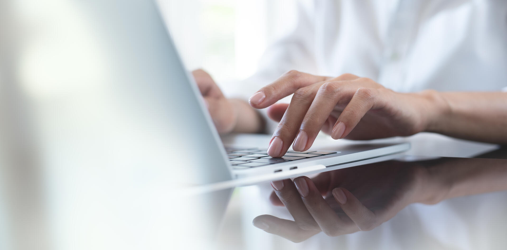Hands typing on a laptop for digital eCMR and transport document management