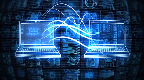 Two laptops with digital connections, symbolizing data transfer and communicatio