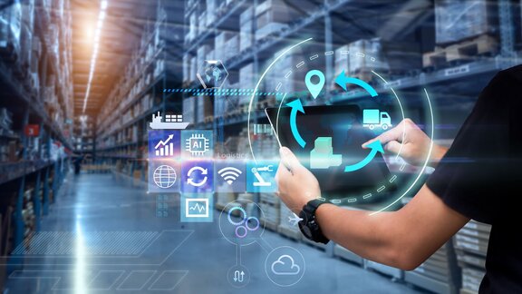 © iStockphoto/B4lls Person using a tablet in a warehouse with overlayed digital logistics and supply chain icons